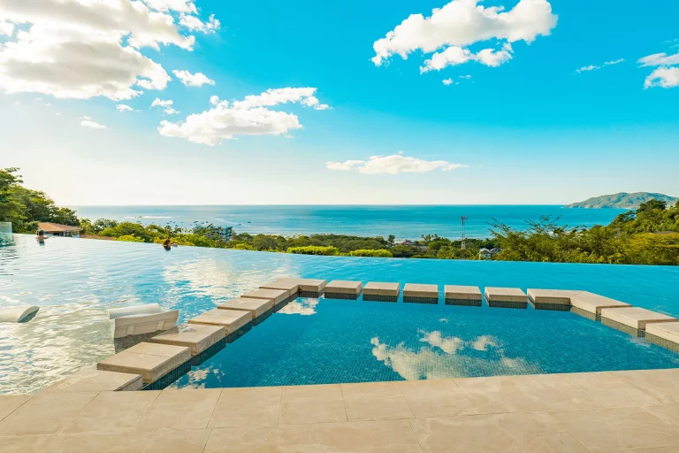 Piscina con bancas y vista a las colinas de Tamarindo_