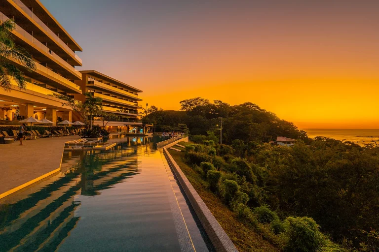 Reflejos al atardecer en la piscina junto a la fachada_