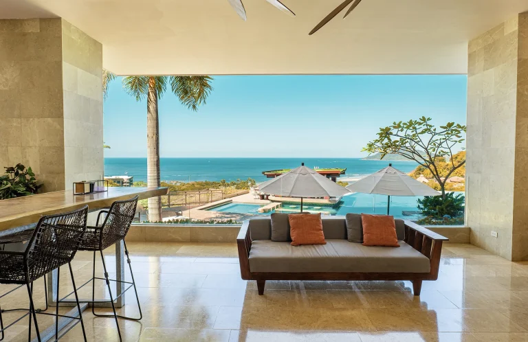 Terraza del lobby con sofá y vista a la piscina y al mar_
